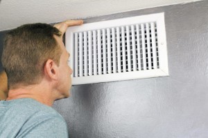 man-looking-into-home-air-vent
